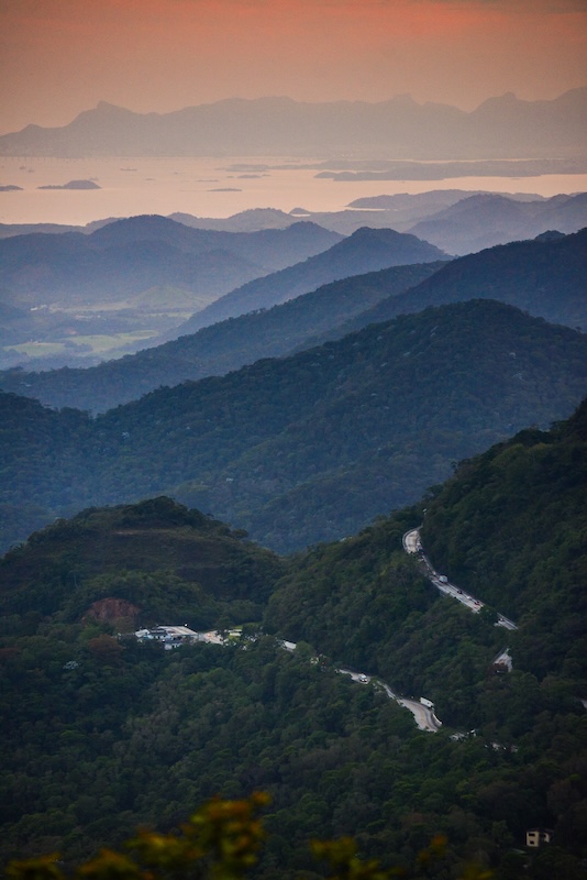 A winding road crossing the Atlantic rainforest of the Serra dos Órgãos National Park and the Guanabara Bay and the mountains of Rio de Janeiro city. Teresópolis, Rio de Janeiro state, southeast Brazil