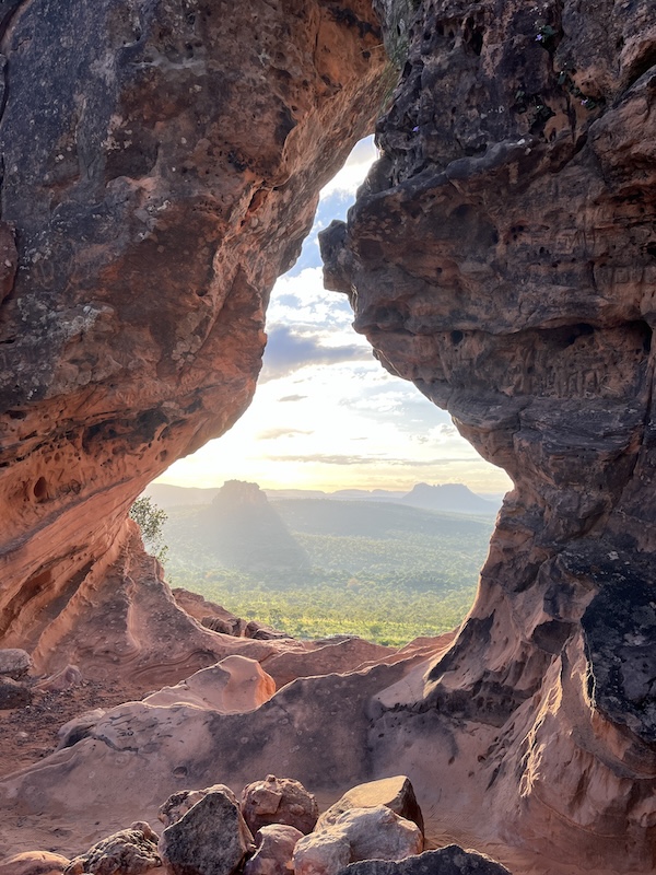 Top of hill sandstone rock eroded hole by rain and wind. View of valley at other side from the top. Cerrado