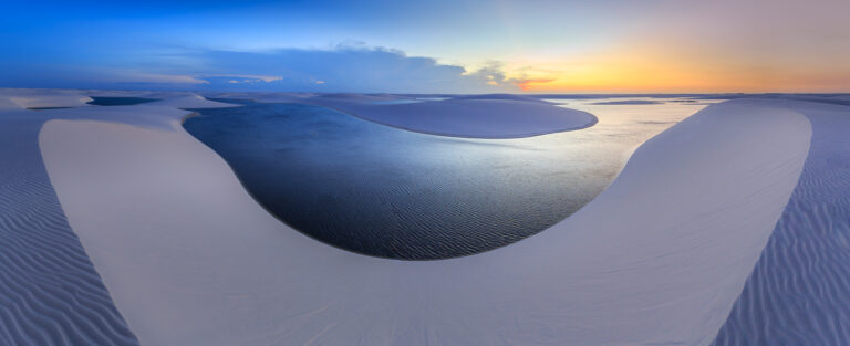 Natural curves of sand dunes and lagoons at dusk.